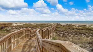 A wooden boardwalk leading to a beach with a clear sky and clouds. - Light, Bright and Airy condo at Amelia Island Plantation (Fernandina Beach)