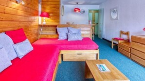 Una habitación acogedora con una cama de madera, un escritorio pequeño y una silla.