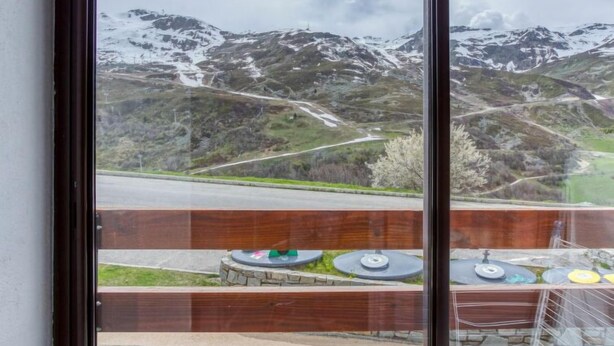 Vista de un paisaje montañoso con picos nevados y una carretera que atraviesa el valle.