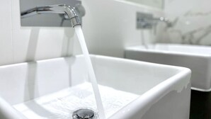 Un baño moderno con un lavabo blanco y grifo cromado.