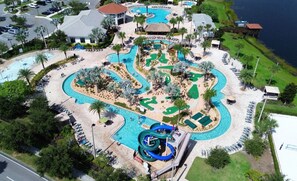 An aerial view of a resort with multiple swimming pools, a water slide, and a golf course. - Artsy 9BR Mansion for 24 people with 6 mil Disney w Pool&Water Park (Kissimmee)