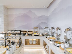 A buffet with various food stations, including hot pots and a variety of dishes.