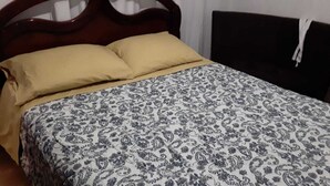 Una cama con una colcha estampada y dos almohadas.