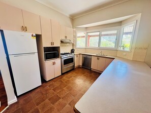 A kitchen with a refrigerator, microwave, stove, oven, and dishwasher. - Treetops Escape   *   Close to CBD   *   Nature   *   Unlimited WIFI (West Albury)
