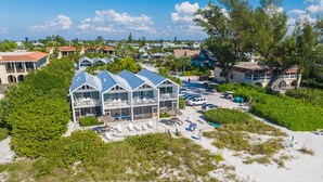 Un hôtel situé en bord de mer, doté de nombreux balcons, d’un parking et d’une plage de sable.