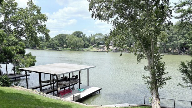A lakeside park with a dock, a covered seating area, and a grassy area with steps leading to the water. - Lakefront Escape / Fishing / Kayaks / Fast WiFi (Seguin)