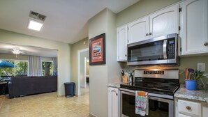 A modern kitchen with white cabinets, a stainless steel microwave, and a built-in oven. - Lakefront Escape / Fishing / Kayaks / Fast WiFi (Seguin)