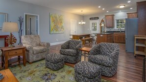 A living room with a sofa, ottomans, a coffee table, and a rug. - BK's Hideaway, with fire-pit and bike storage (Pisgah Forest)