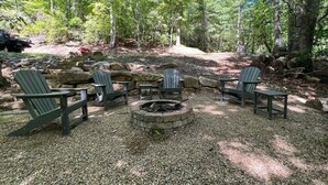 A fire pit surrounded by Adirondack chairs in a forested area. - BK's Hideaway, with fire-pit and bike storage (Pisgah Forest)