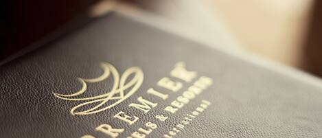 Un libro encuadernado en cuero negro con texto dorado grabado que dice "PREMIER HOTELS & RESORTS INTERNATIONAL".