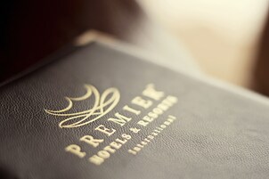 Un libro encuadernado en cuero negro con texto dorado grabado que dice "PREMIER HOTELS & RESORTS INTERNATIONAL".