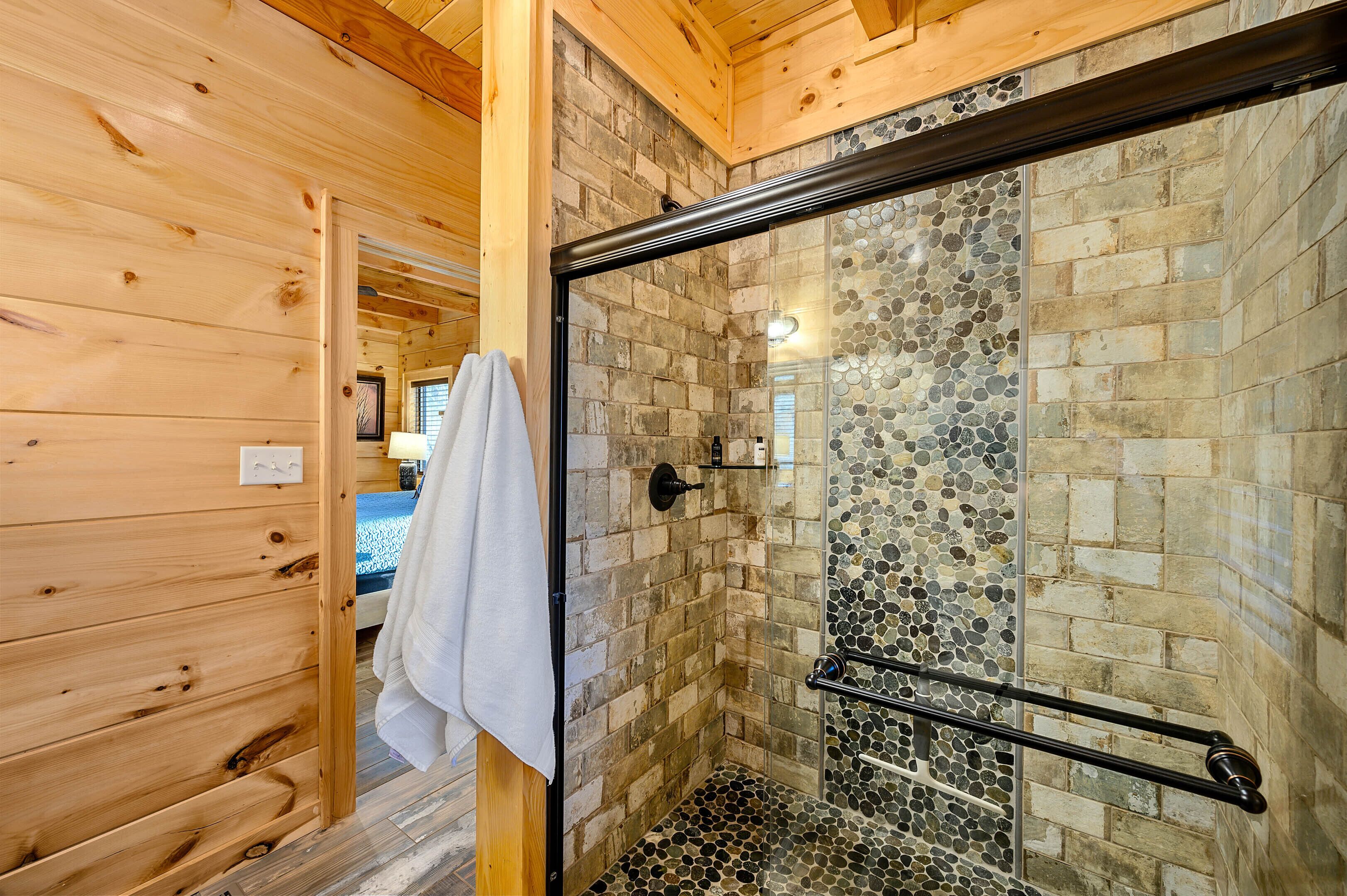 A wooden interior with a glass shower enclosure and a tiled wall.