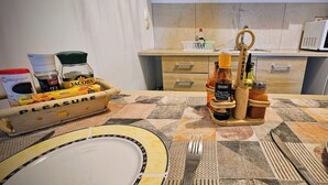 Une cuisine équipée d’un four à micro-ondes, d’une machine à café et d’une variété de condiments disposés sur le comptoir.