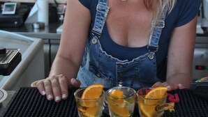 A person seated at a table with three glasses of a beverage, a menu, and a cash register. - Room-pleasure Room 2 By The Sea (Santorini)