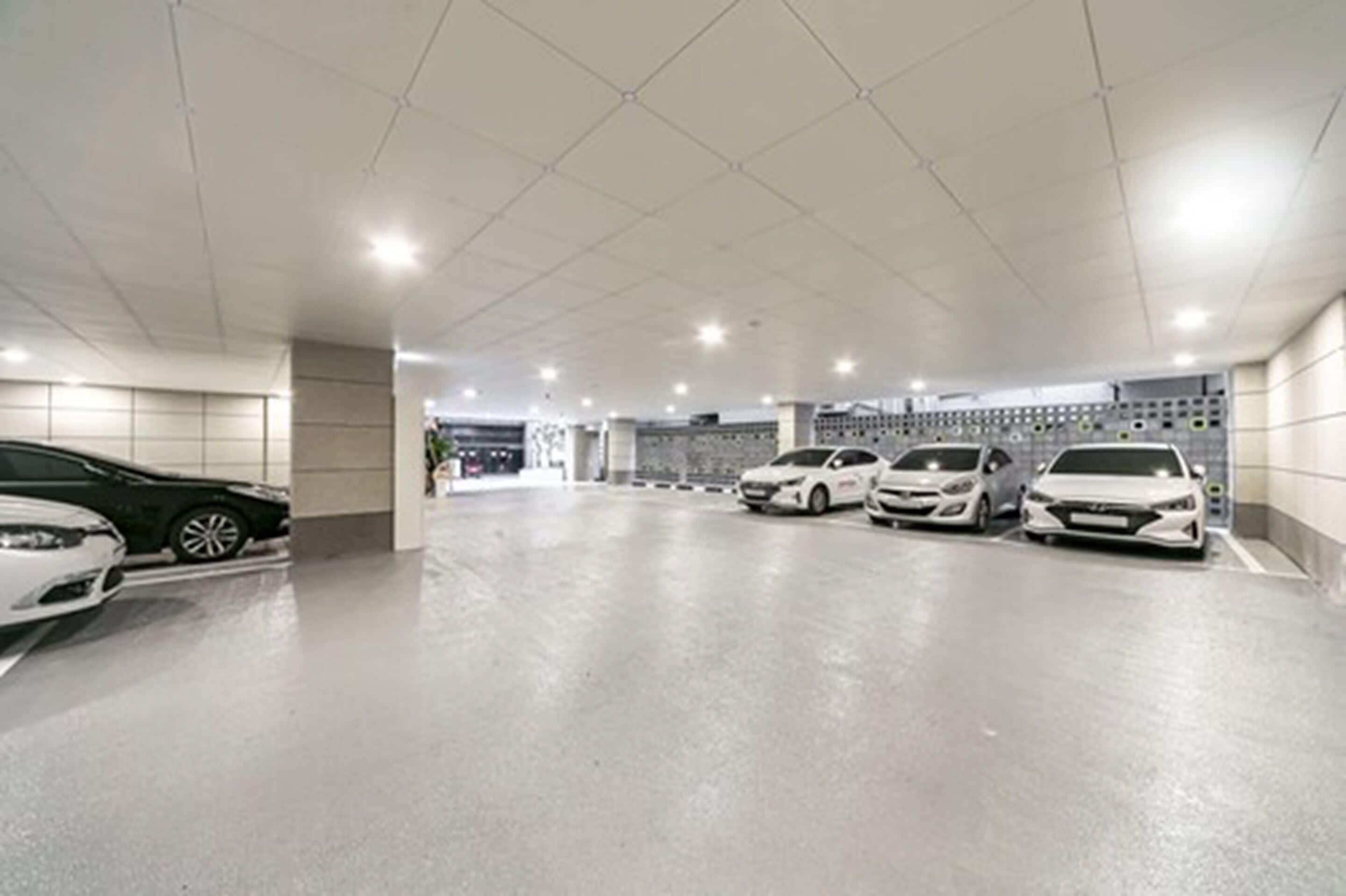 A parking garage with multiple cars parked in designated spaces.