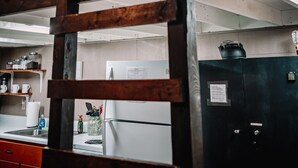 Ein Stockbett in einem Zimmer mit Küchenzeile, einem Fenster und einer Deckenleuchte.