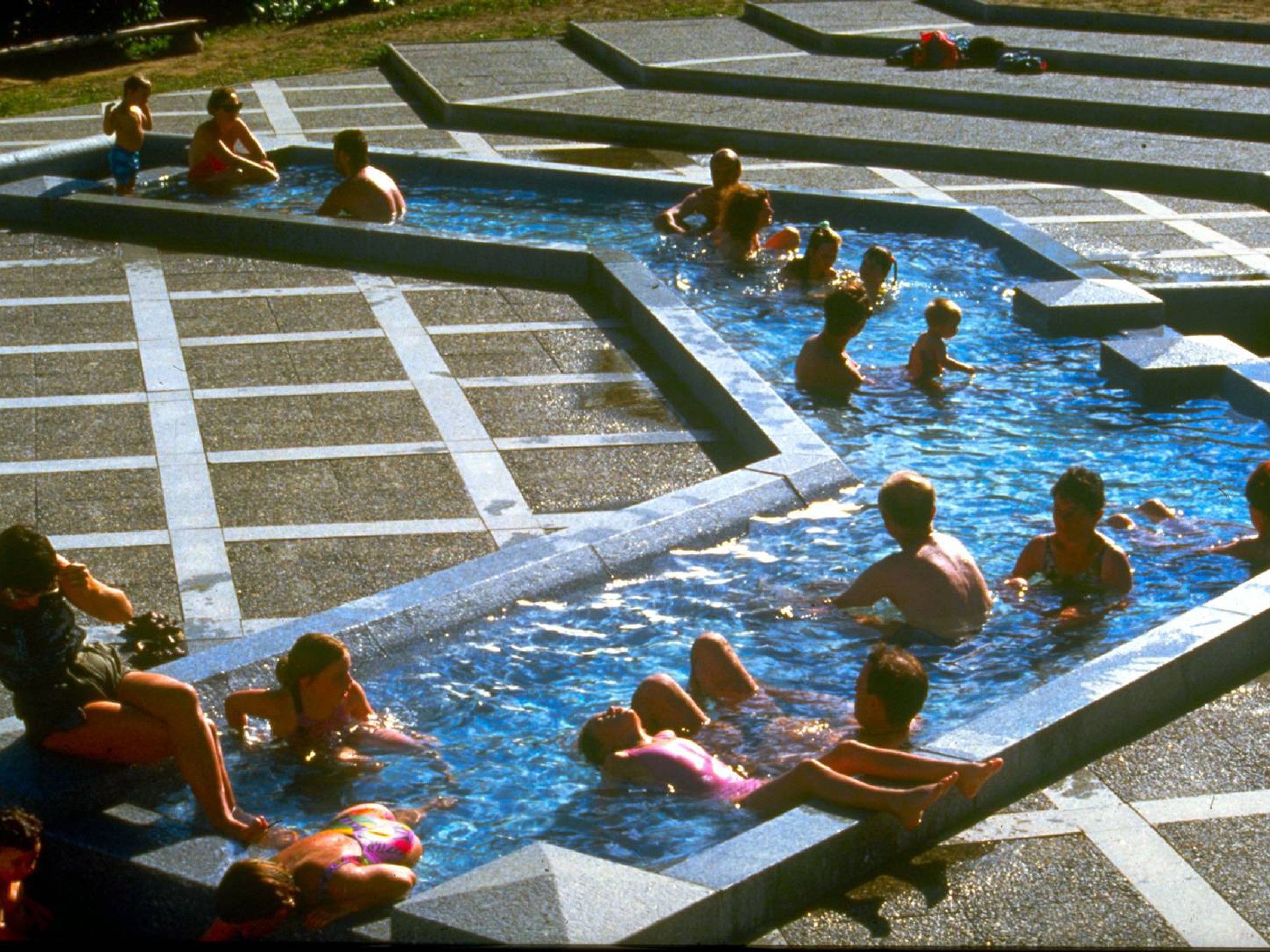 A swimming pool with multiple lanes and a tiled deck surrounding it.
