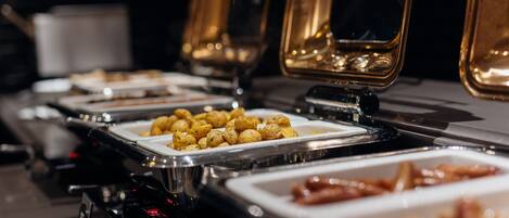 A buffet setup with various food items in trays.