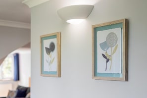 Dues obres florals emmarcades sobre un mur blanc.