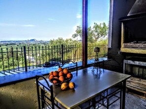 Enjoy a romantic meal for two in this serene outdoor dining area with a view of the surrounding landscape and distant mountains.