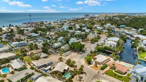 A coastal residential area with houses, a marina, and a clear view of the ocean.