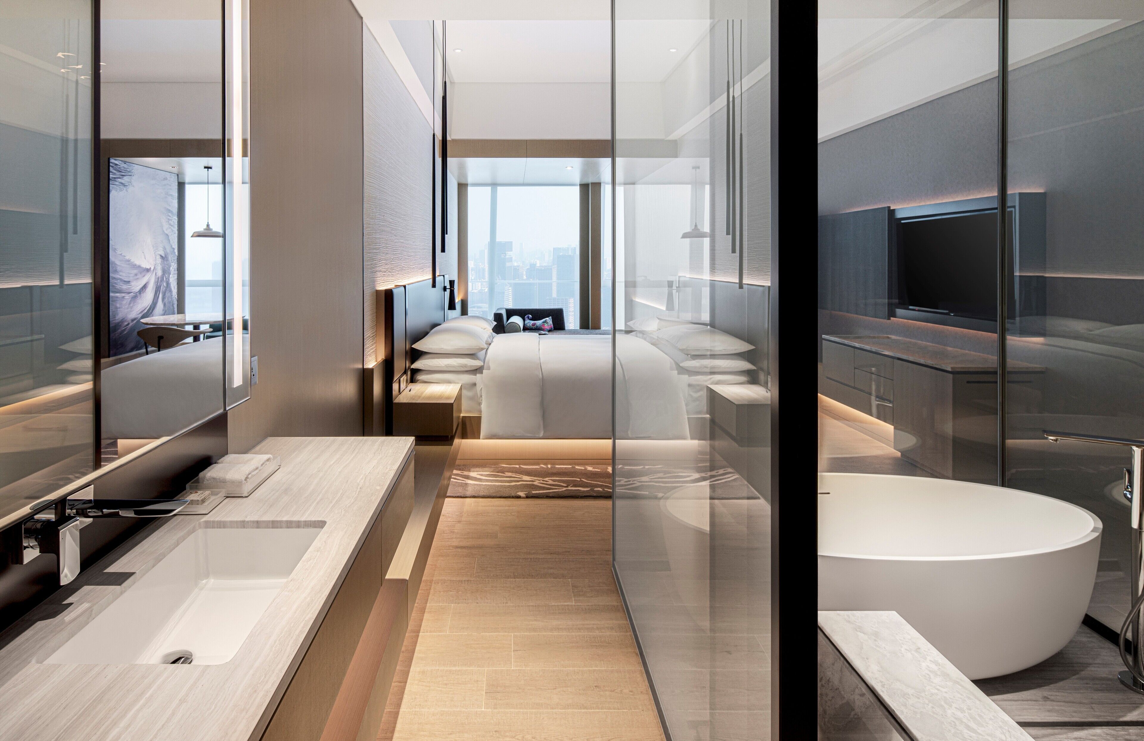 A modern hotel bathroom with a large bathtub, a separate shower area, and a vanity with a sink.