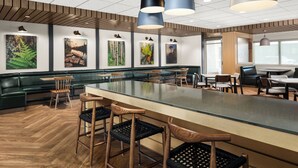 A modern dining area with a central island, wooden chairs, and artwork on the walls. - Fairfield Inn & Suites by Marriott Duluth (Duluth)