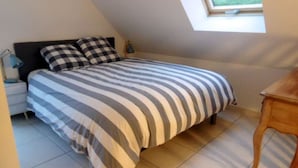 Una camera da letto con un letto, un comodino, una lampada e una finestra.