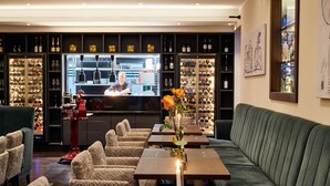 Ein Restaurant mit Barbereich, Sitzgelegenheiten und einer Weinauslage.
