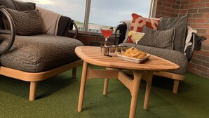 A cozy seating area with two sofas, a small wooden table, and a martini glass. - Homewood Suites by Hilton Tuscaloosa Downtown (Tuscaloosa)