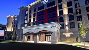 A modern hotel with a prominent entrance, multiple floors, and a clear sky. - Homewood Suites by Hilton Tuscaloosa Downtown (Tuscaloosa)