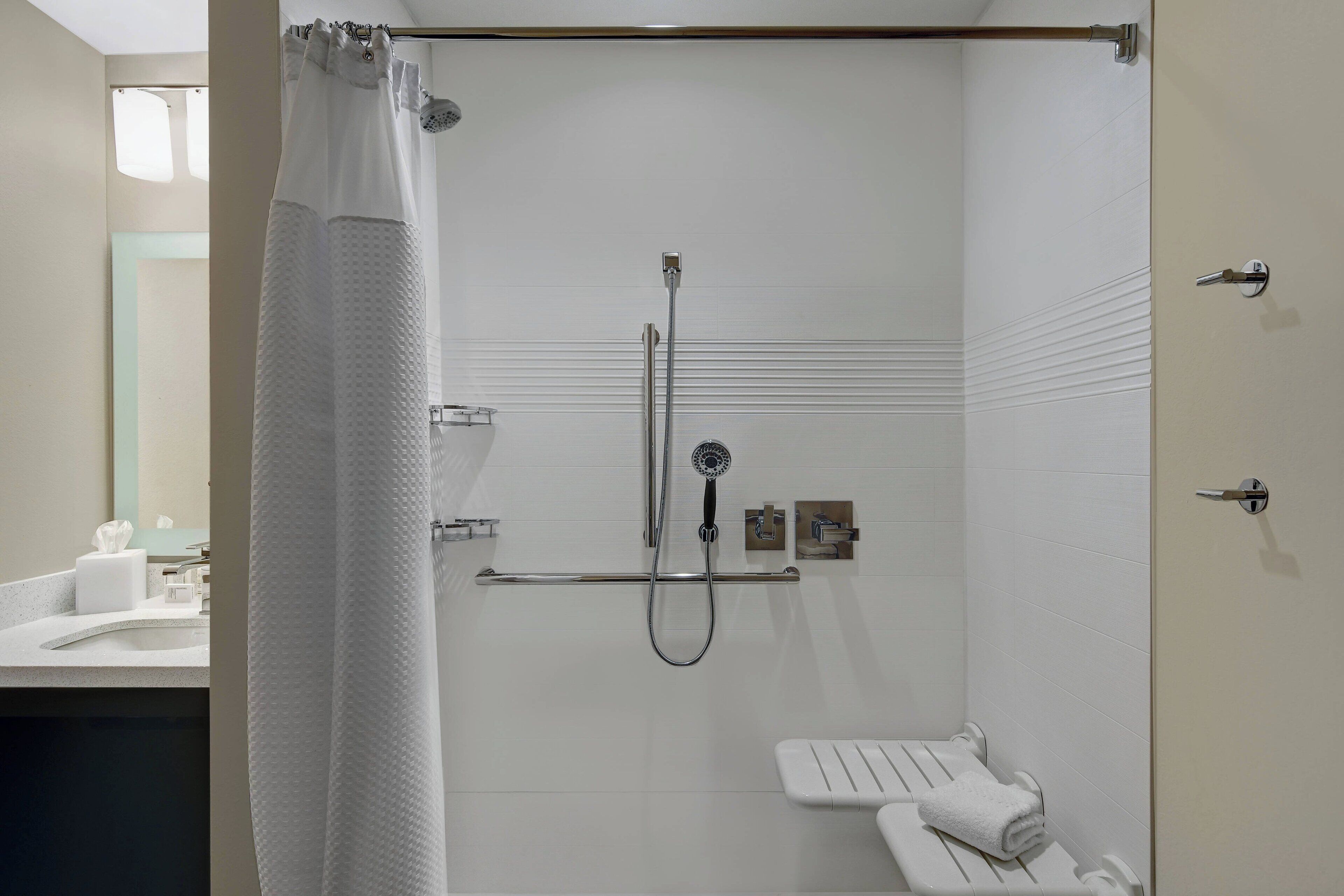 Un baño moderno con ducha, toallero y retrete.