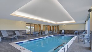 A swimming pool with lounge chairs and a ceiling light fixture. - TownePlace Suites by Marriott Lima (Lima)