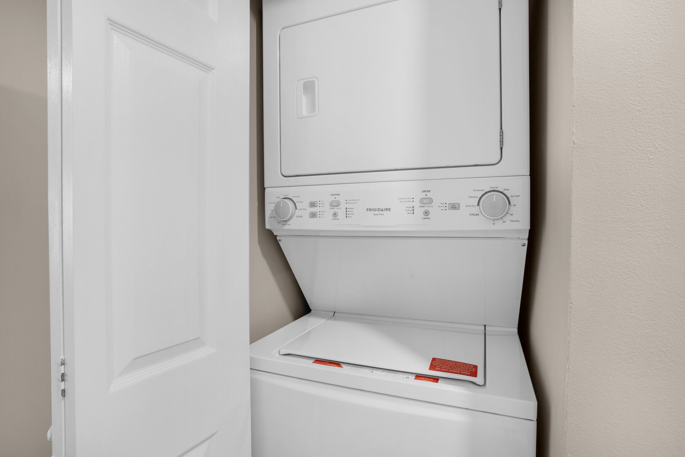 A white wall-mounted washer and dryer unit with control panels and a door.