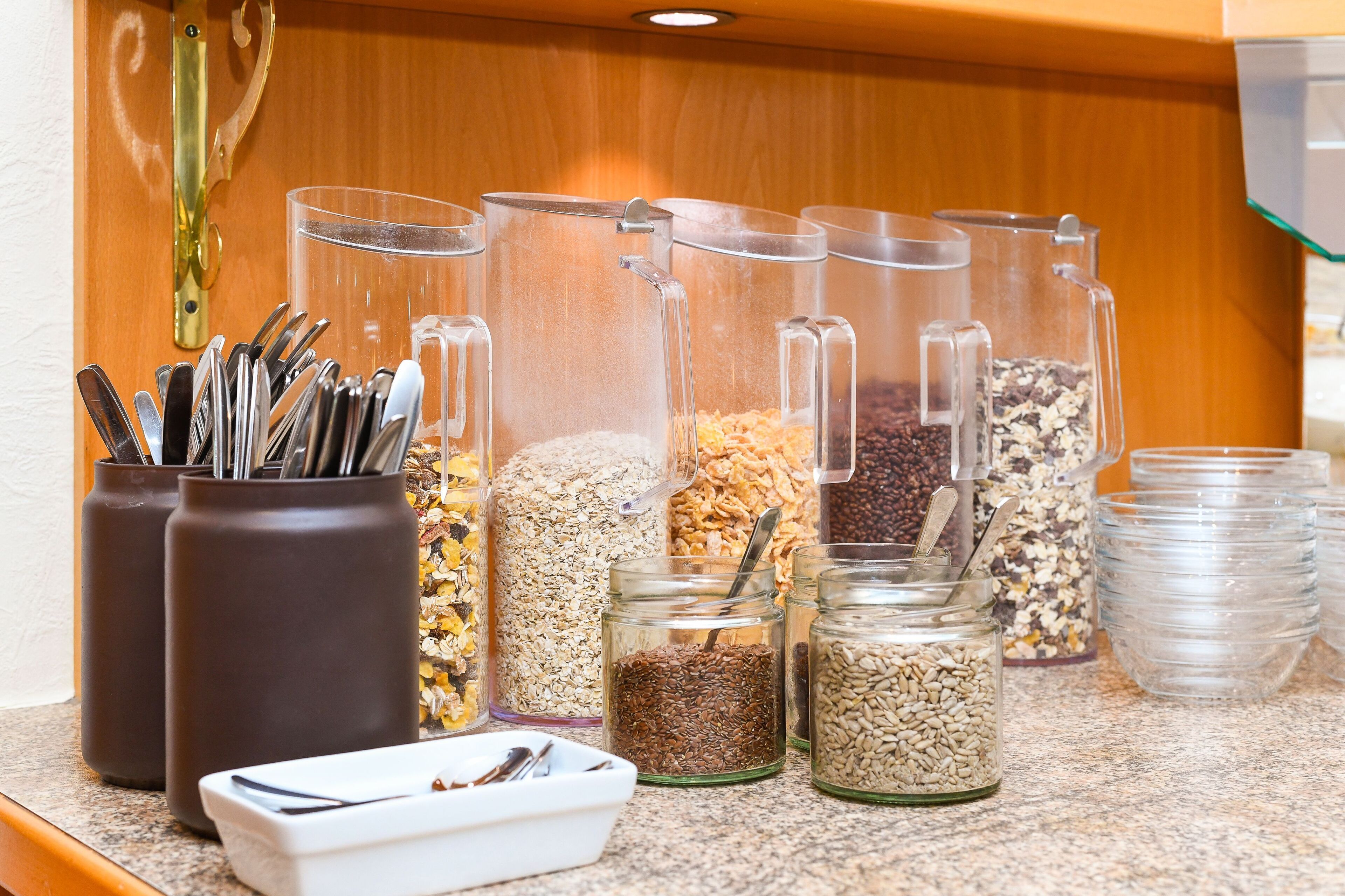 A breakfast bar with various food items and utensils.