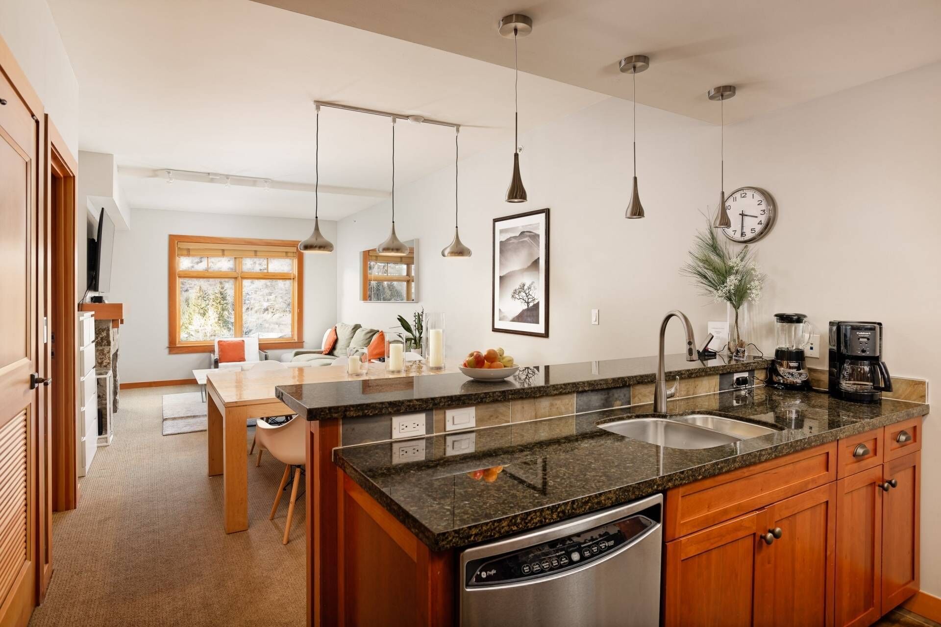 A modern kitchen with granite countertops, stainless steel appliances, and wooden cabinets.