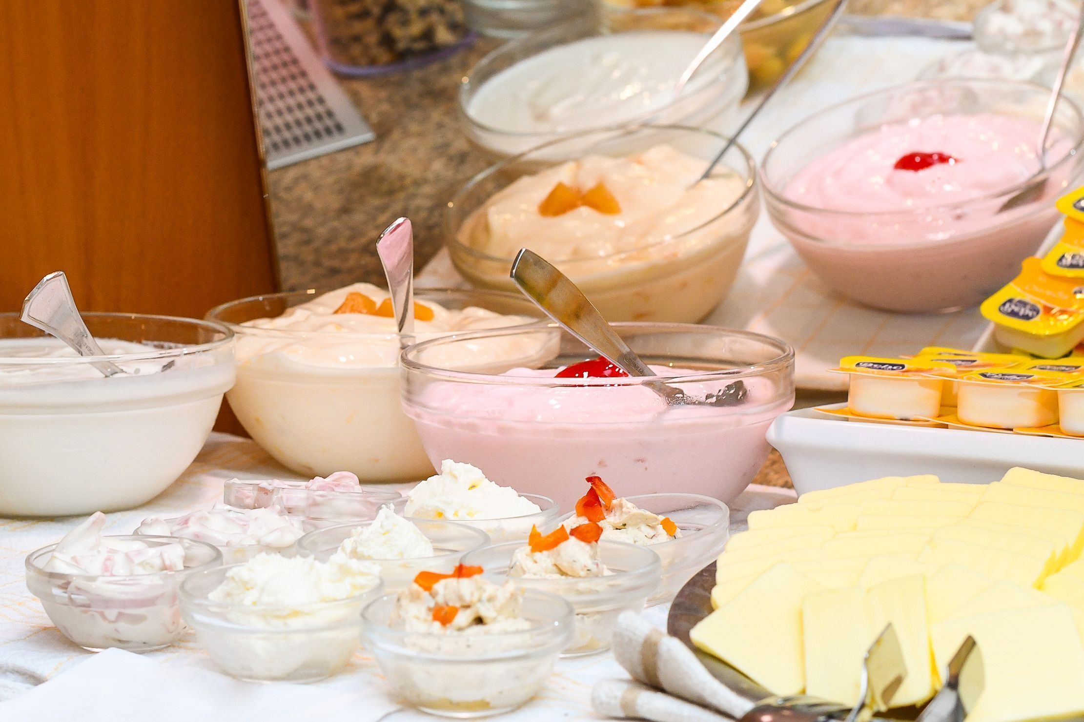 Variedad de alimentos, incluyendo tazones de postres cremosos y recipientes pequeños adornados con fruta.