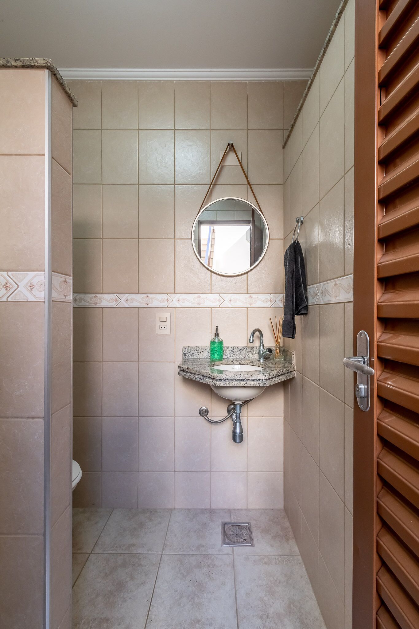 Une petite salle de bain avec un lavabo, un miroir et un porte-serviettes.