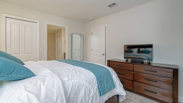 A bedroom with a bed, a dresser, and a television. - You and Your Family Will Love This Luxury Mansion on Champions Gate Resort, Orlando Mansion 3726 (Davenport)