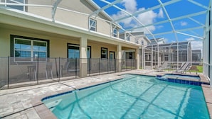 A swimming pool with a glass enclosure, a covered patio area, and a view of a residential building. - You and Your Family Will Love This Luxury Mansion on Champions Gate Resort, Orlando Mansion 3726 (Davenport)
