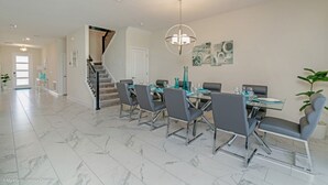 A spacious dining area with a marble floor, modern chairs, and a chandelier. - You and Your Family Will Love This Luxury Mansion on Champions Gate Resort, Orlando Mansion 3726 (Davenport)