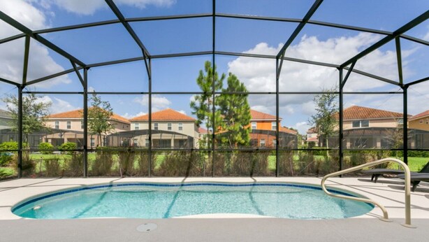 A covered outdoor swimming pool with a view of residential buildings in the background.