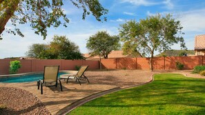 A backyard with a swimming pool, two lounge chairs, and a brick wall. - Near Great Shopping & Dining! Pool Table & Games! (Glendale)