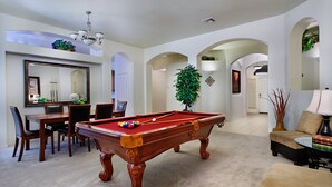 Un salon spacieux comprenant une table de billard, un coin repas et un espace salon confortable.