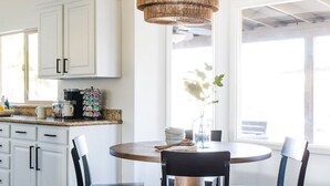 A bright kitchen with white cabinets, a coffee maker, and a vase with flowers on the counter. - Perfect 4 Bdrm Home With Pool and Game Room! (Phoenix)