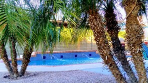 A swimming pool surrounded by palm trees. - Backyard Playground! Golf Sport Court & Hot Tub! (Glendale)