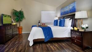 A bedroom with a bed, dresser, nightstand, TV, potted plant, and artwork on the wall. - Backyard Playground! Golf Sport Court & Hot Tub! (Glendale)