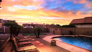 A backyard with a swimming pool, lounge chairs, and a small green area. - Backyard Playground! Golf Sport Court & Hot Tub! (Glendale)