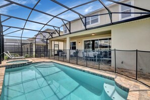 A swimming pool with a glass enclosure, patio furniture, and a covered outdoor area. - At Last You can Rent the Perfect Luxury Villa on Solara Resort, Minutes From Disney World, Orlando Villa 3613 (Kissimmee)