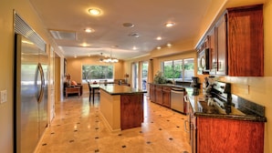 A modern kitchen with a central island, built-in appliances, and a large window providing natural light. - Just Listed! Kierland Home w Htd Pool and Hot tub (Scottsdale)